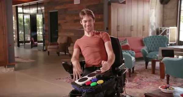 Disabled man using Trabasack Curve Connect wheelchair lap tray and bag with games console handset on top