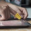 Nimble one-finger cutter opening a pack of ham