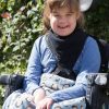 Girl in a wheelchair wearing Seenin kerchief bib in navy