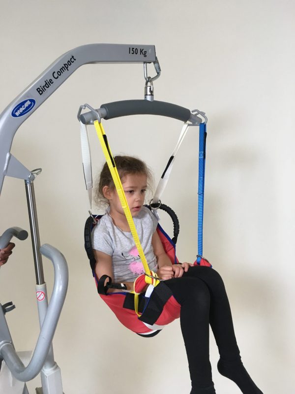 Disabled girl being moved in ProMove sling with straps attached to the hoist