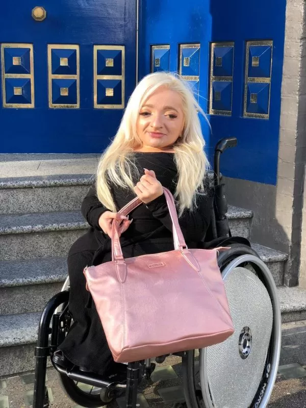 Sam Renke holding her rose gold handbag