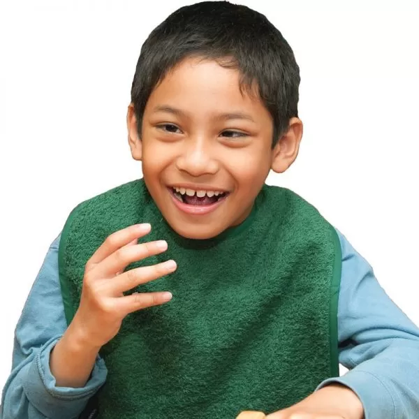 Disabled boy wearing Seenin bib apron in green