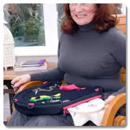 Woman in wheelchair using Trabasack Curve Connect wheelchair lap tray and bag