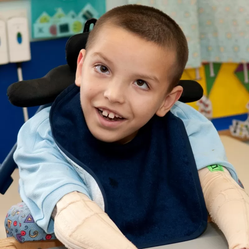 Disabled boy wearing Seenin bib in navy