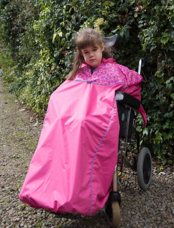 Disabled girl in fuchsia Seenin total waterproof wheelchair cover