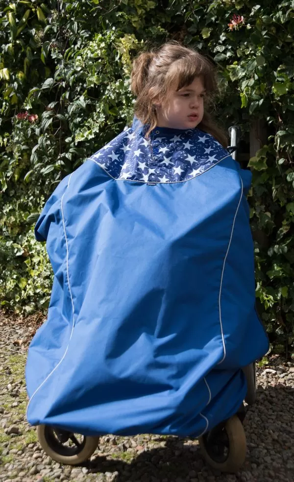 Disabled girl in navy Seenin total waterproof wheelchair cover with star pattern