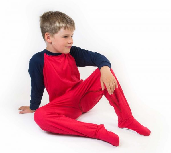Young boy sat down wearing Seenin children's red and navy zip sleepsuit
