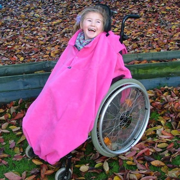 Disabled girl in woodland in fuchsia Seenin total fleece wheelchair cover