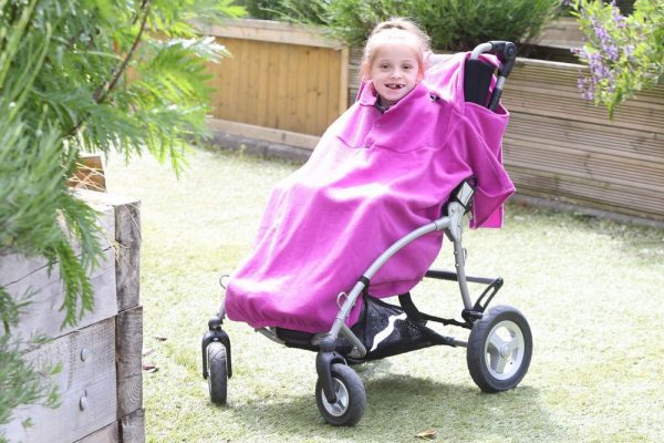 Disabled girl in fuchsia Seenin total fleece wheelchair cover