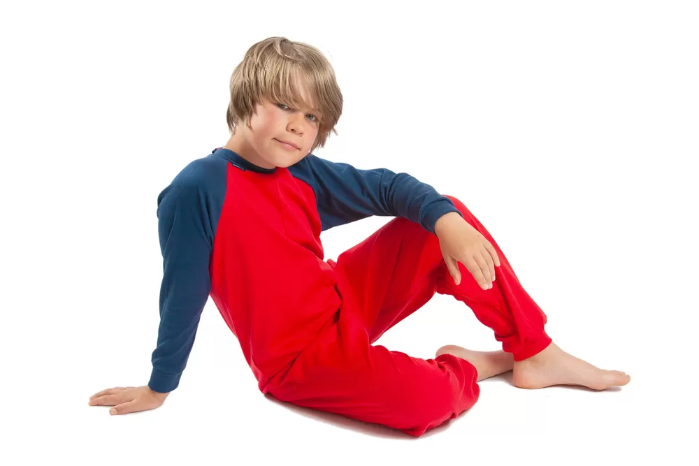 Young boy sat down wearing Seenin children's red and navy zip sleepsuit