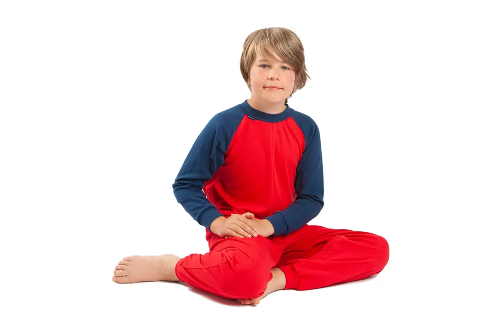 Young boy sat down wearing Seenin children's red and navy zip sleepsuit