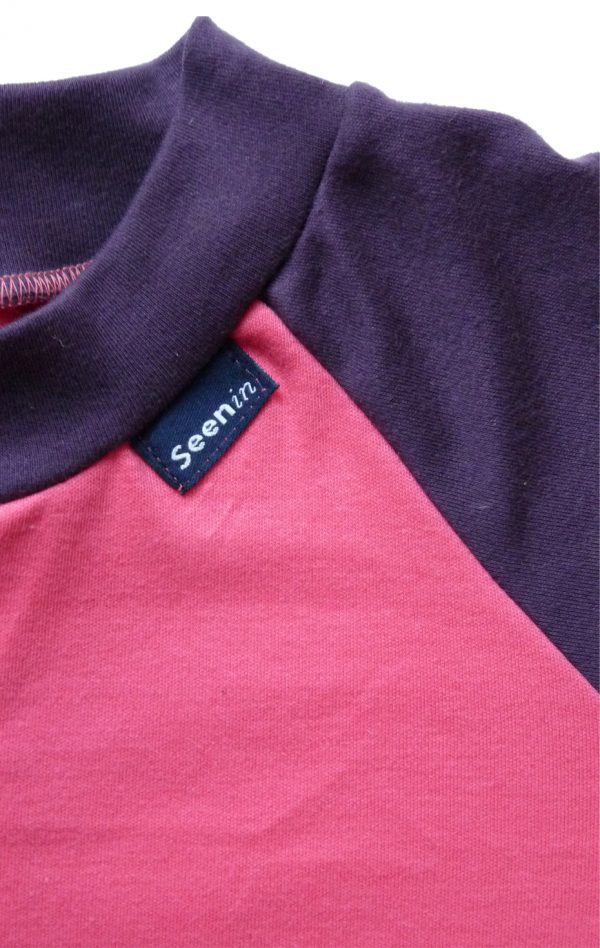 Close up of front of Seenin children's pink and plum zip sleepsuit