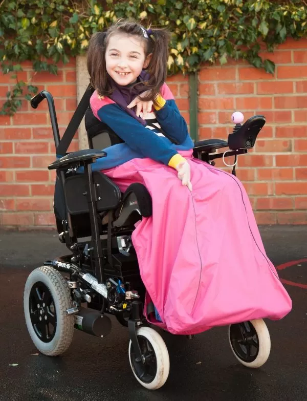 Disabled girl wearing pink Seenin waterproof wheelchair leg cover