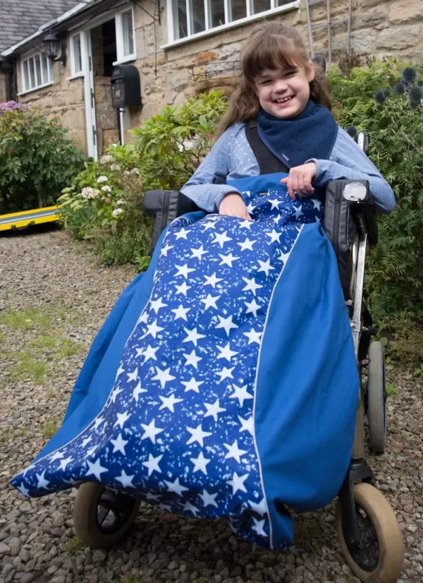 Disabled girl in navy star print Seenin waterproof wheelchair leg cover