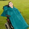 Disabled man in field wearing teal Seenin total fleece wheelchair cover
