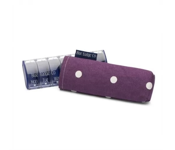 Image is a photograph of a plastic pill box with a dark purple with white spot-designed case cover.
