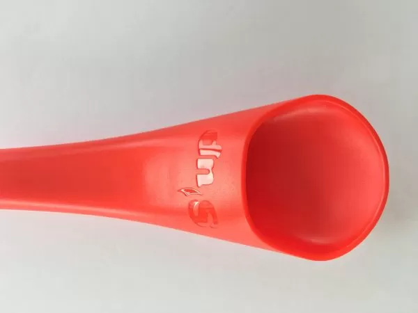 Image is a close-up photograph showing the internal channel of the S'up Spoon Mini in red