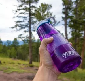 purple water bottle being help by a person, made easier by using a strip of grip tape