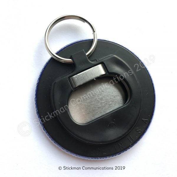 Image is a photograph of the back of the keyring, which is made of black plastic that functions as a bottle opener.