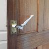 Image is a photograph of a brass internal door handle with a Tru Grip door handle extension kit installed