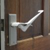 Image is a photograph of a brown wooden internal house door with a Tru Grip door handle extension kit installed