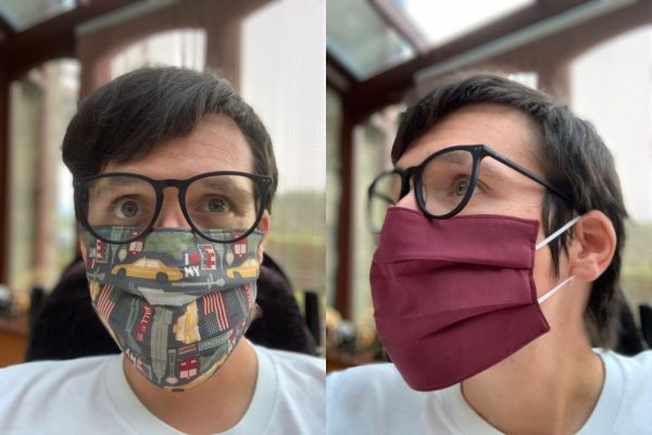Image is two photographs side-by-side, of a man wearing a New York-themed fabric face mask. In the first photograph he is facing the camera to show the design and fit of the mask. The fabric's design features yellow taxis, New York street signs, the Empire State building and other iconic New Yorkn imagery. In the second image the man is looking to the left, and he is wearing the mask inside-out to illustrate that the inner lining is burgundy in colour.