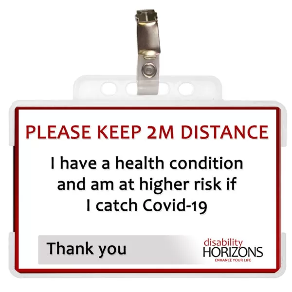 Image is a plastic ID card to promote social distancing, in a plastic ID card holder with badge clip for attaching to shirts, coats, blouses etc. Bright red text in capitals reads: "PLEASE KEEP 2M DISTANCE". Under this black text reads: "I have a health condition and am at higher risk if I catch Covid-19. Thank you". The bottom righthand corner features the Disability Horizons logo.
