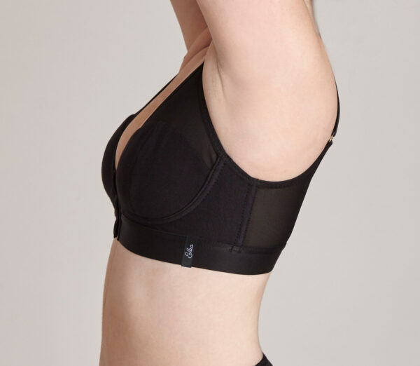 Image shows the side view of a lady wearing a black Elba London bra with her arms raised in the air