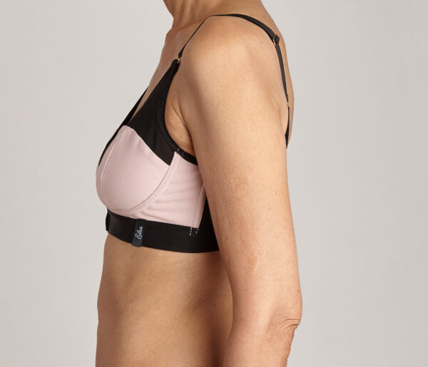 Image shows the side view of a lady wearing a blush Elba London bra with her arms by her side