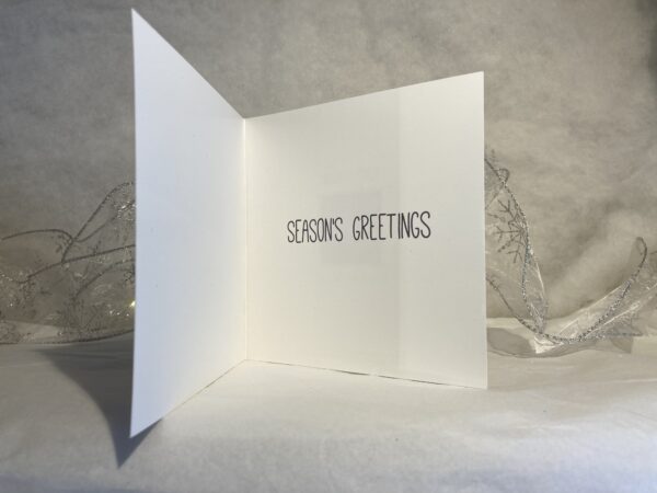 Image is a photograph showing the inside of the Perky Penguins christmas cards with text which reads "SEASON'S GREETINGS"