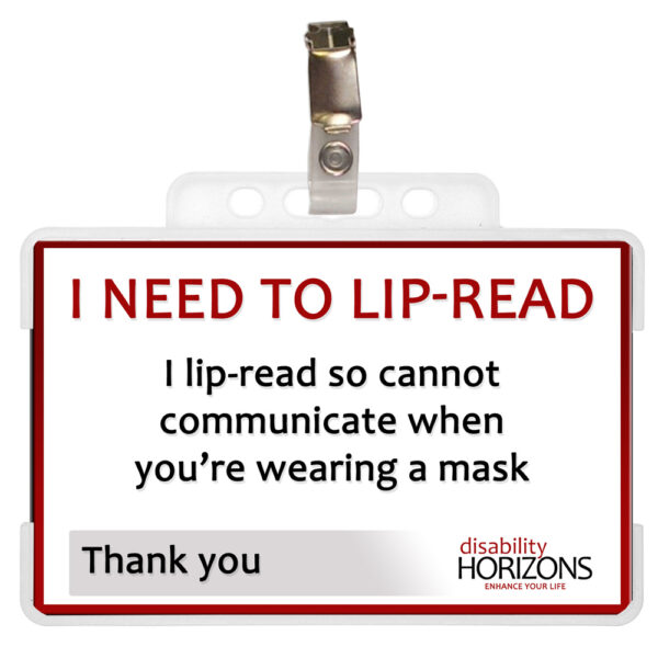 Image is a photograph of a lip-reading ID card in a plastic case with badge clip. Text on the ID card reads: "I NEED TO LIP-READ. I lip-read so cannot communicate when you're wearing a mask. Thank you"