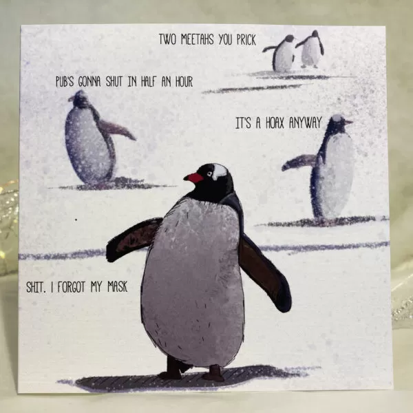 Image is a photograph of an illustrated christmas greeting card featuring penguins walking through the snow. Each penguin is making a humorous statement about Covid-19. Text reads: "TWO MEETAS YOU PRICK. PUB'S GONNA SHUT IN HALF AN HOUR. IT'S A HOAX ANYWAY. SHIT, I FORGOT MY MASK"