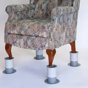 Buckingham chair raisers on an armchair with wooden legs and a grey and brown pattered fabric