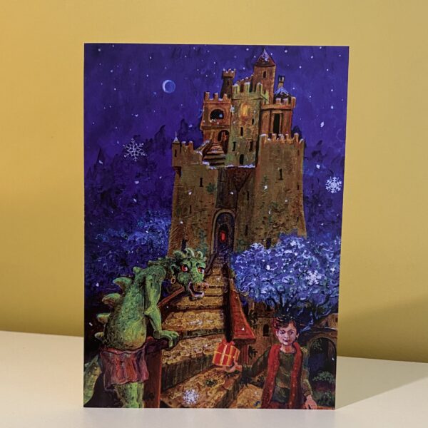 Image is a photograph of a Peter Rodulfo christmas card entitled "The Gift" featuring a boy handing a ribbon-wrapped gift to a dragon with a mystical castle in the distance.