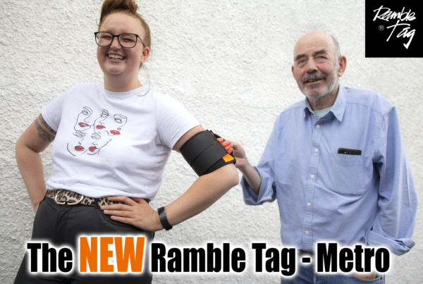 Image is a photograph of Ciara wearing a Ramble Tag guidance aid and Tom holding the guidance strap.