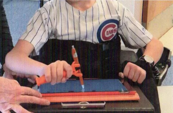 Boy using the functional hand to hold a tablet stylus to use a tablet computer