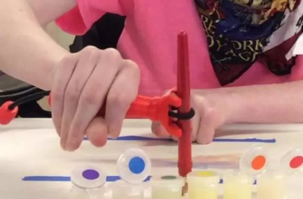 girl using the functional hand to hold a paint brush to paint a picture