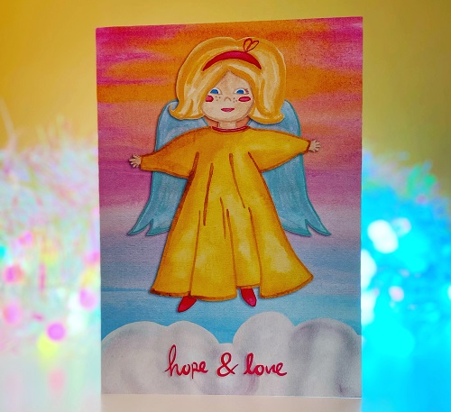 Handmade Vintage Angel Christmas card with an angle in a yellow dress with blue wings, blonde hair and blue wings floating above a cloud that says hope & love on it