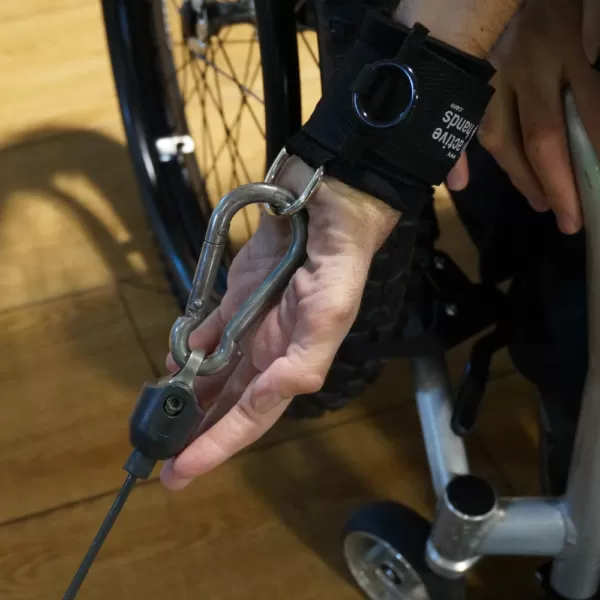 Image showing the D ring aid worn on a mans wrist being used to pull an exercise rope