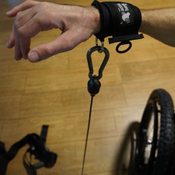 Image showing the D ring aid worn on a mans wrist being used to pull an exercise rope