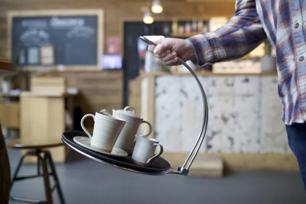 Man in a chequed shirt swinging the tipsi tray to show how stable the tray is.