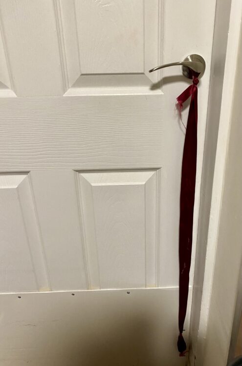 Long red ribbon tied to a door handle