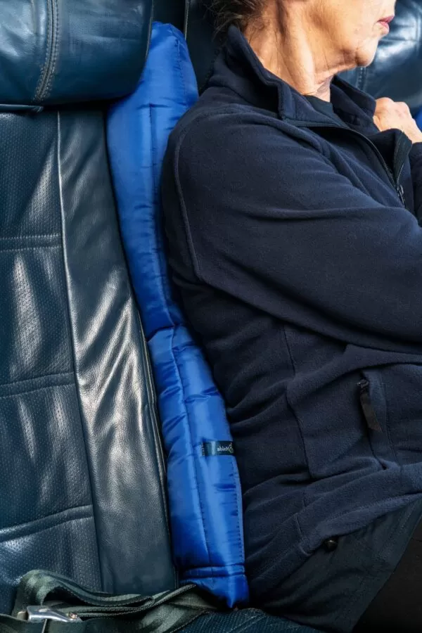 a womans back rested against the blue padded covers