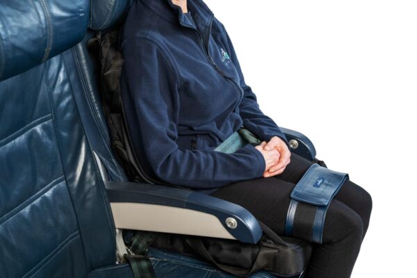 a woman sitting in the seat with the ableStrap around her thighs