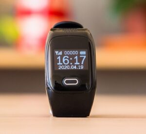 Personal Alarm Watch smartwatch in black sat on a table showing the time, battery power, date and step count at zero