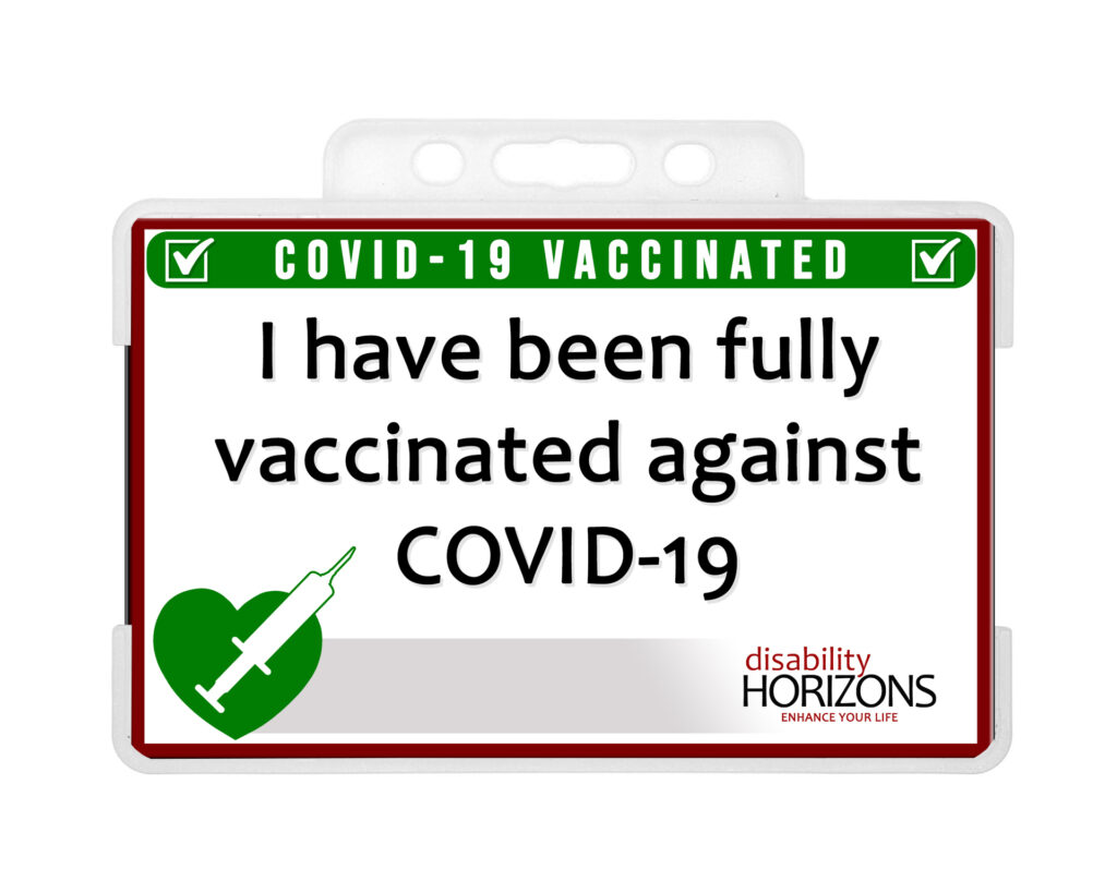 Image is of the Covid-19 vaccination ID card in a hard, clear, plastic card holder, featuring a green heart with a syringe at the bottom left, the Disability Horizons logo to the bottom right, and the following text "COVID-19 VACCINATED. I have been fully vaccinated against COVID-19"