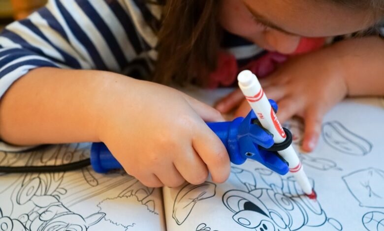 Young girl using the Functionhand to hold a pencil to colour in