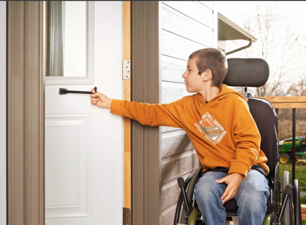 Child using the t pull door closer from his wheelchair