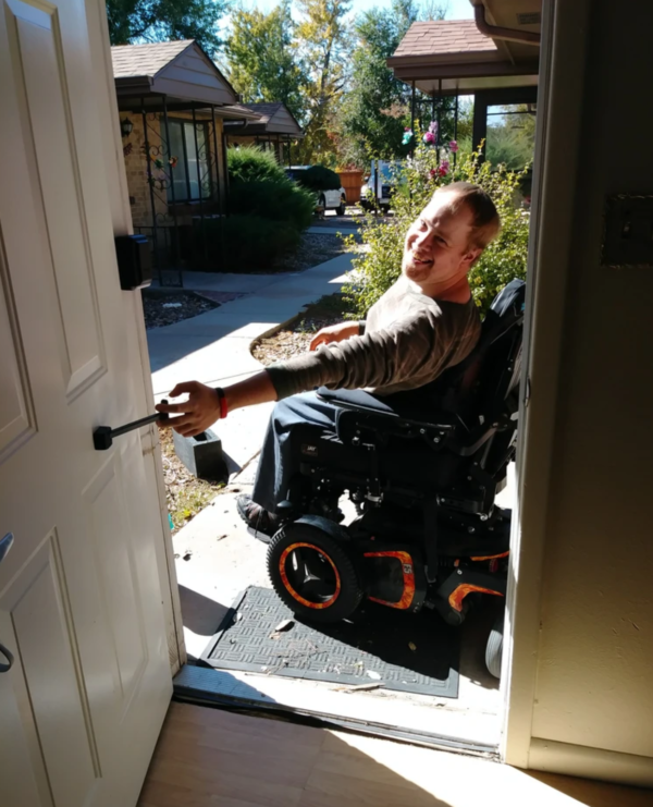 man in wheelchair using the tpull on an external door