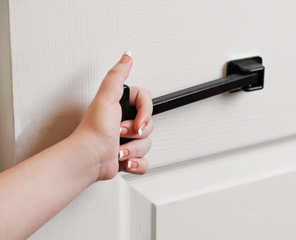 tpull disabled door closer fitted on a white door being grasped